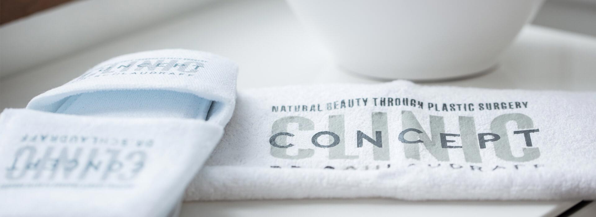 Image de chaussons et serviette avec le logo de Concept Clinic, Clinique de chirurgie esthétique à Genève